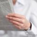 A close up of an individual holding a newspaper