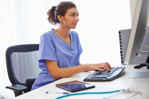 nurse in front of computer typing on a keyboard